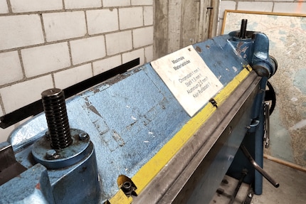 Using the folding machine to bend sheet metal at the desired angle.